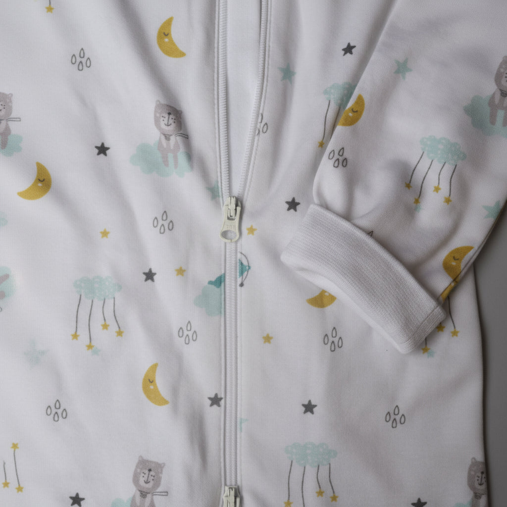 Vit pyjamas med dragkedja och mönster av moln, månar och stjärnor i ekologisk bomull – detaljbild från Snödroppen Himmelens vänner kollektion