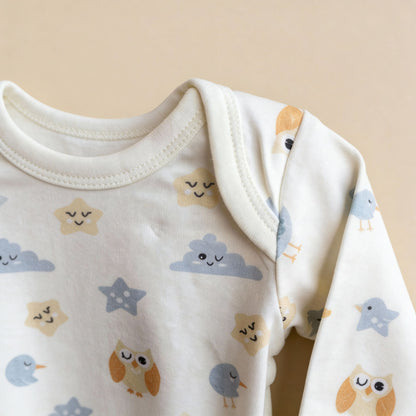 Detaljbild av ekologisk babybody från kollektionen Himlens Vänner med fågel-, moln- och stjärnmönster runt halsringningen