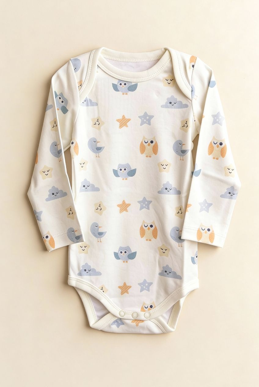 Ekologisk babybody från kollektionen Himlens Vänner med fågel- och stjärnmönster, flatlay på beige bakgrund