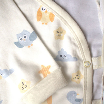 Detaljbild av ekologisk omlott-body från kollektionen Himlens Vänner med kantband och tryckknappar samt fågel-, moln- och stjärnmönster