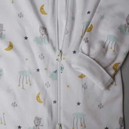 Vit pyjamas med dragkedja och mönster av moln, månar och stjärnor i ekologisk bomull – detaljbild från Snödroppen Himmelens vänner kollektion