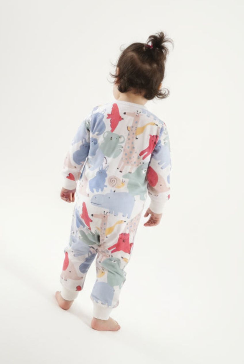 Barn som bär ekologisk babypyjamas från kollektionen Safari Vänner med färgglatt safarimönster, sedd bakifrån på vit bakgrund