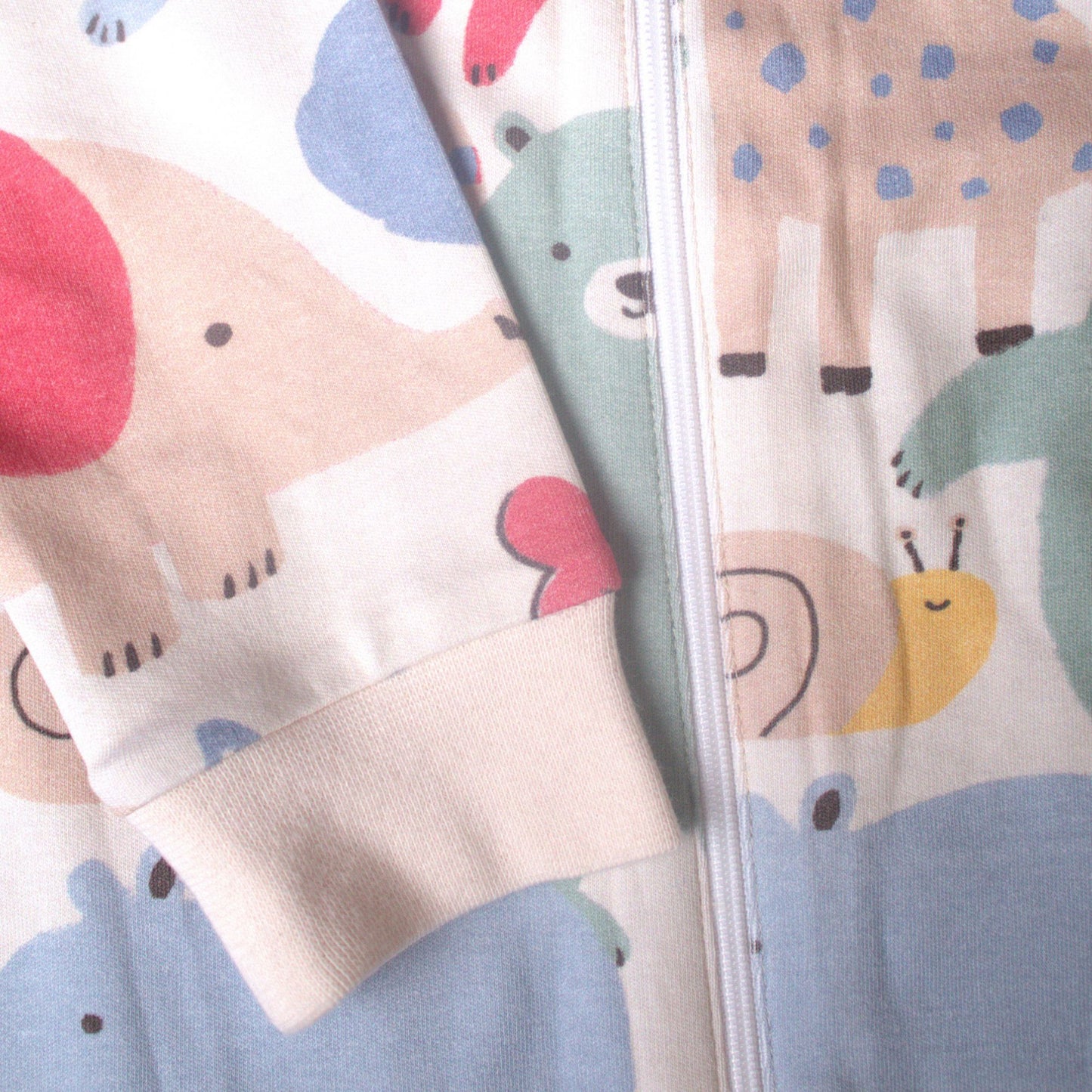 Detaljbild av ekologisk babypyjamas från kollektionen Safari Vänner med mjuk ärmmudd och färgglatt safarimönster