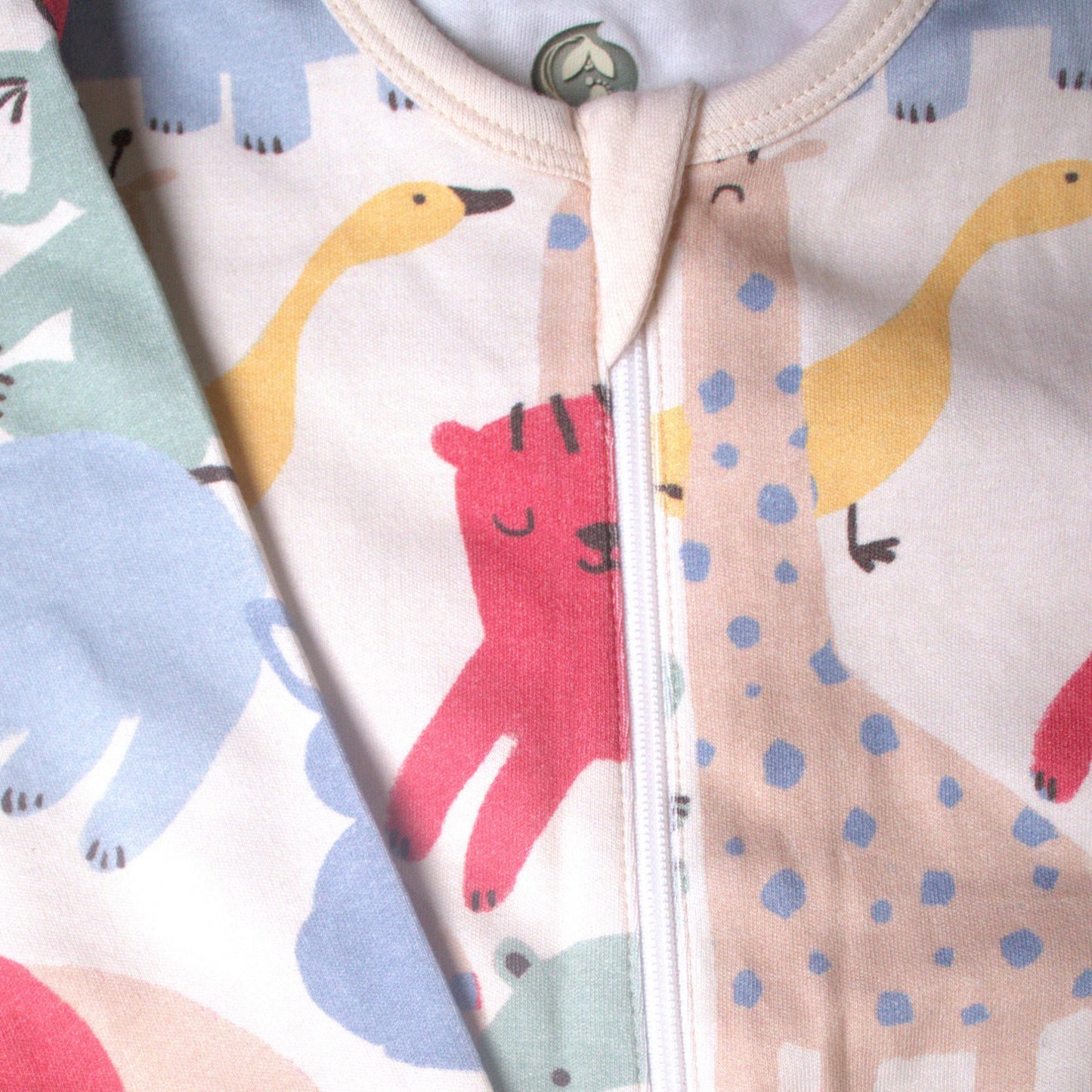 Detaljbild av ekologisk babypyjamas från kollektionen Safari Vänner med dragkedja och färgglatt safarimönster