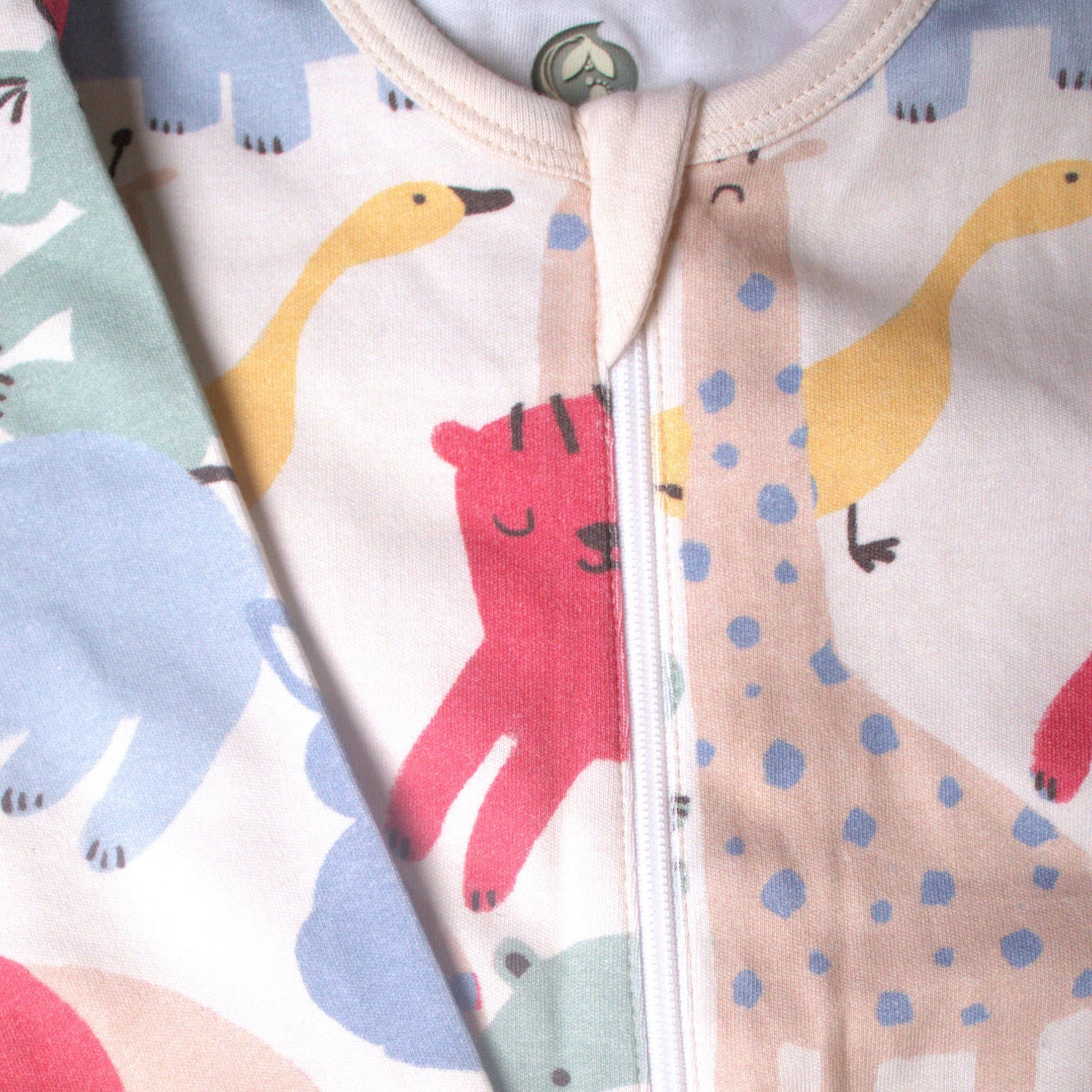 Detaljbild av ekologisk babypyjamas från kollektionen Safari Vänner med dragkedja och färgglatt safarimönster