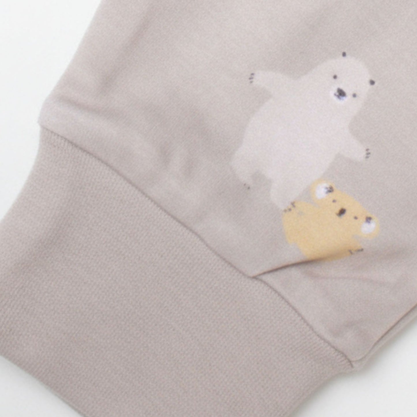 Detaljbild av ekologiska babybyxor från kollektionen Safari Vänner med beige mudd och djurmönster