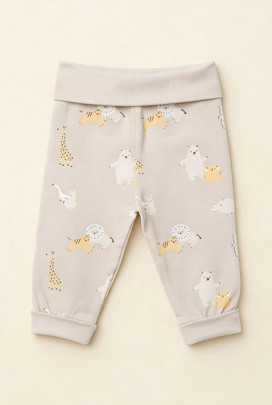 Ekologiska babybyxor från kollektionen Safari Vänner med djurmönster i beige toner, flatlay på ljus bakgrund