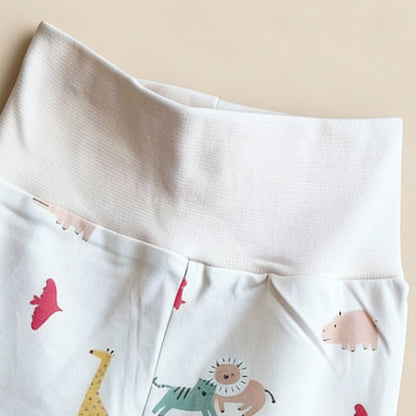 Detaljbild av ekologiska babybyxor från kollektionen Safari Vänner med mjuk vit midja och färgglatt djurmönster