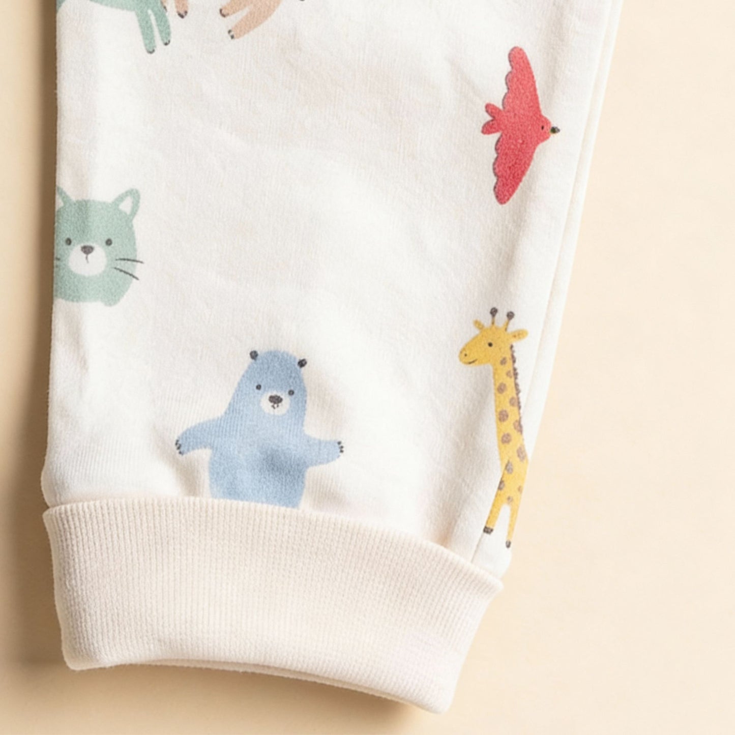 Detaljbild av ekologiska babybyxor från kollektionen Safari Vänner med vit mudd och färgglatt djurmönster